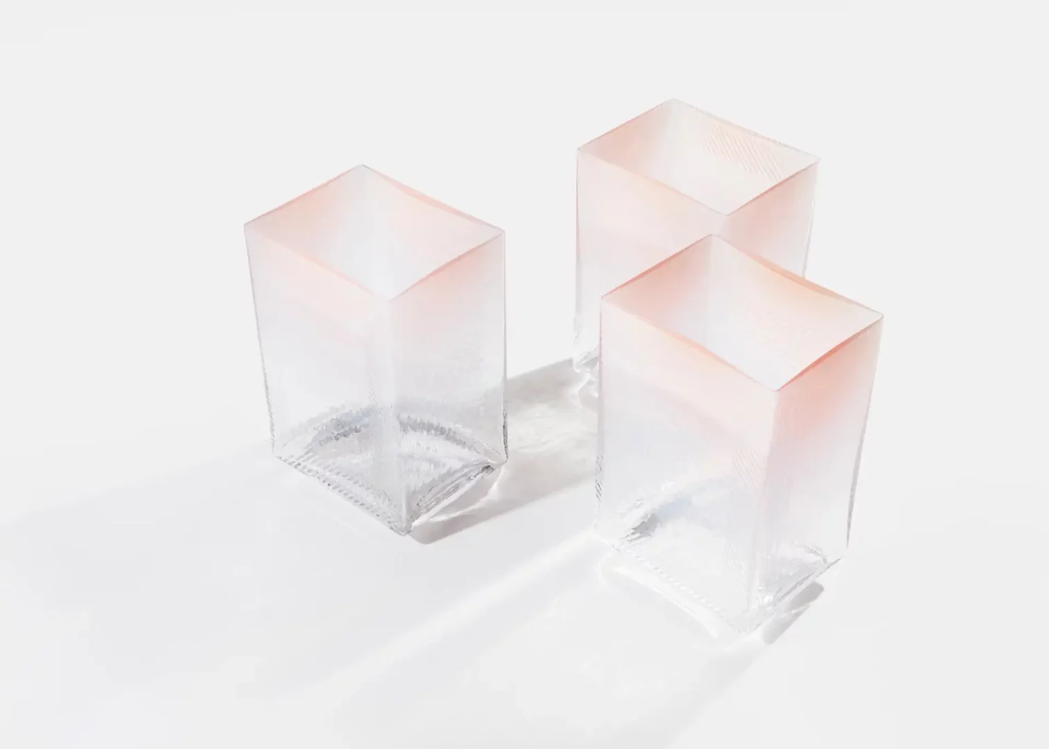 Three translucent pink-tinted cubes on white background.