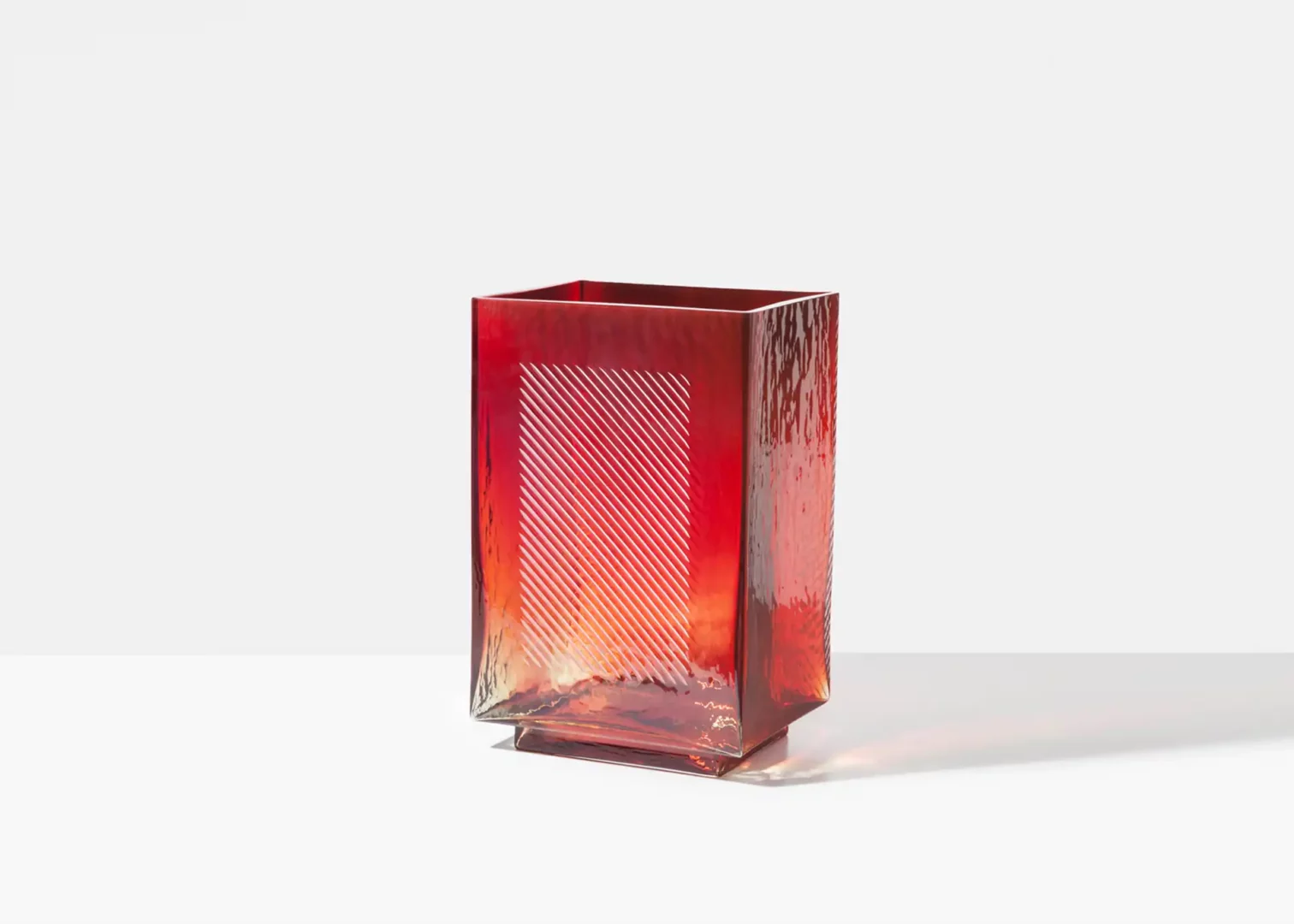 Red textured glass vase on white background.