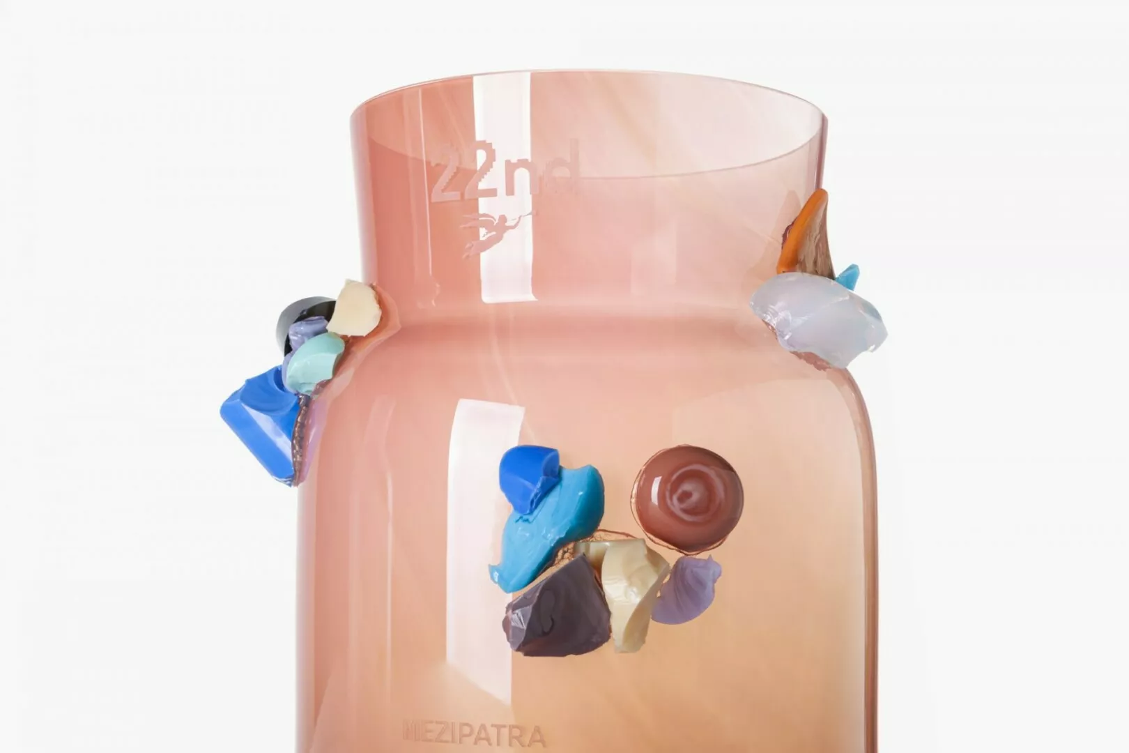 Artistic glass vase with colorful melted wax details.