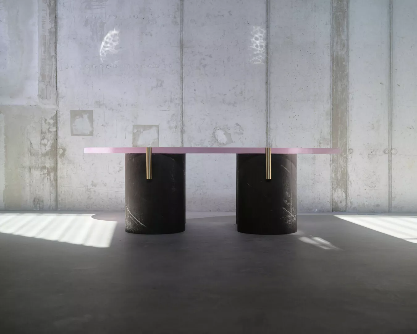 Minimalist table with pink top on black cylindrical bases.