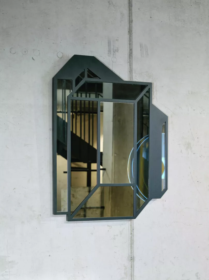 Modern geometric mirror on concrete wall.