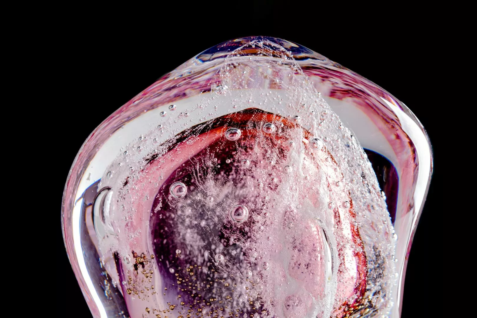 Colorful frozen bubble with sparkling ice, black background.
