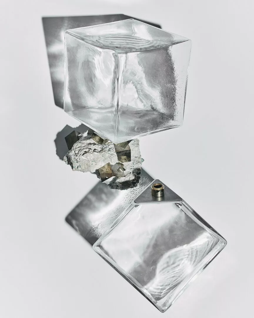 Clear ice cube sculpture with reflective surfaces and shadows.