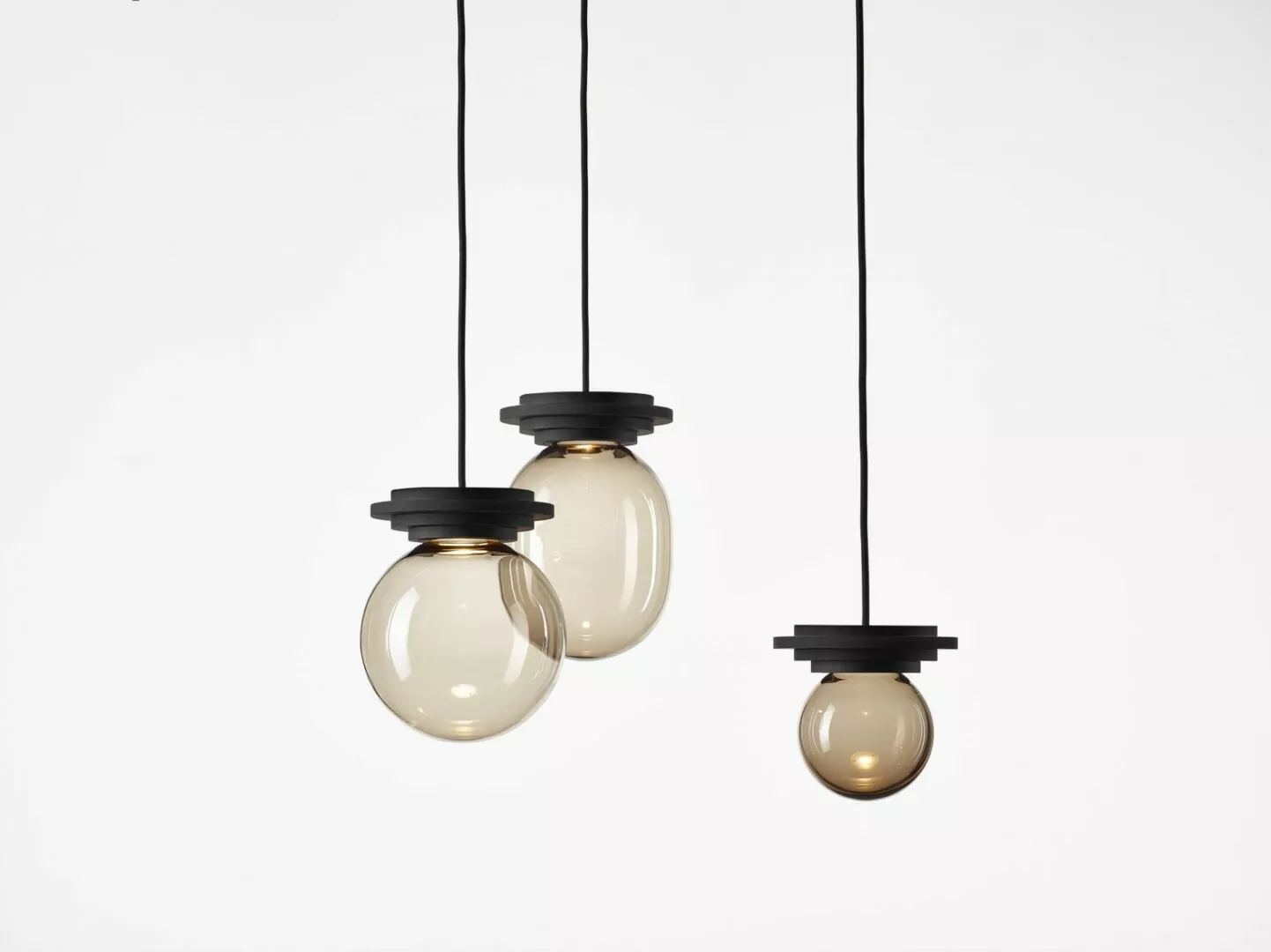 Three hanging modern pendant lights with black fixtures.