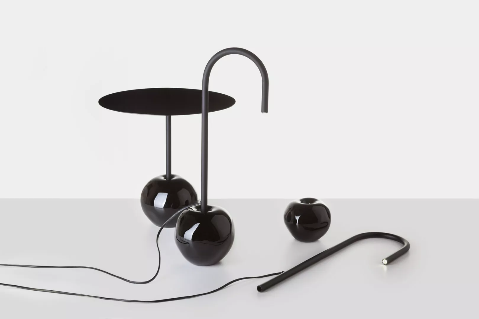 Modern black sculptural table lamp on white background.