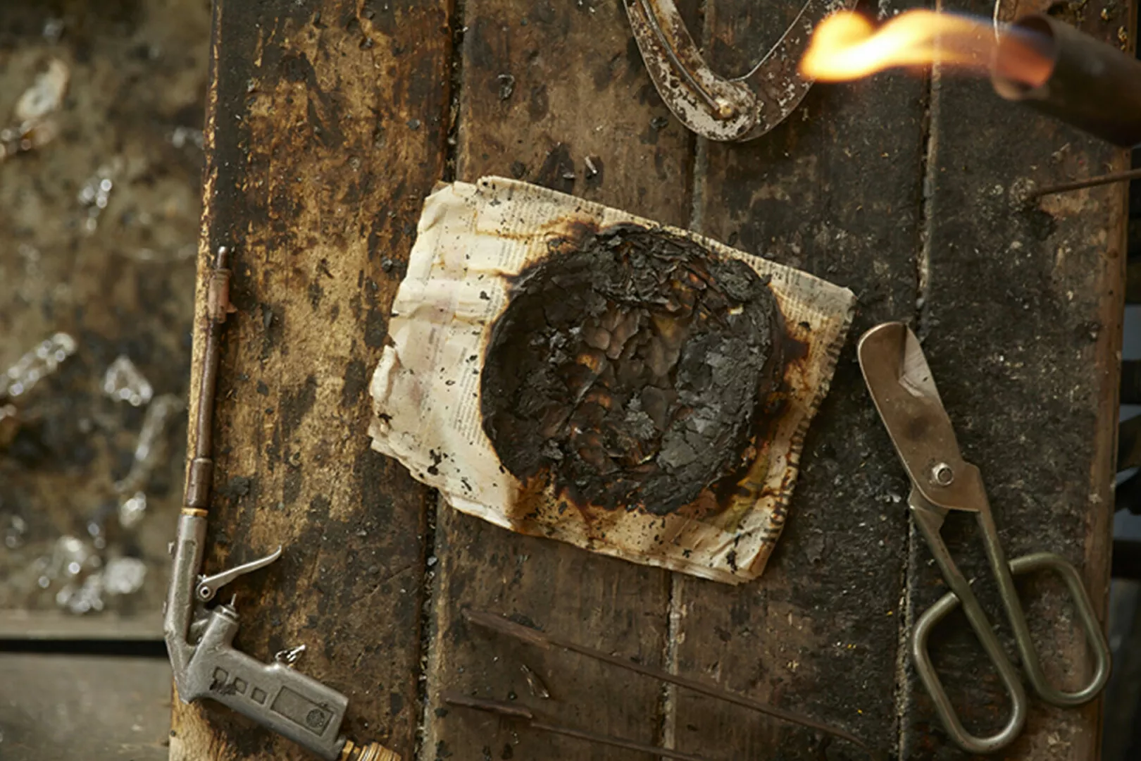 Burnt book welding tools on wooden surface.