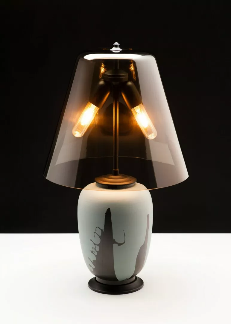 Elegant lamp with translucent shade and artistic base design.