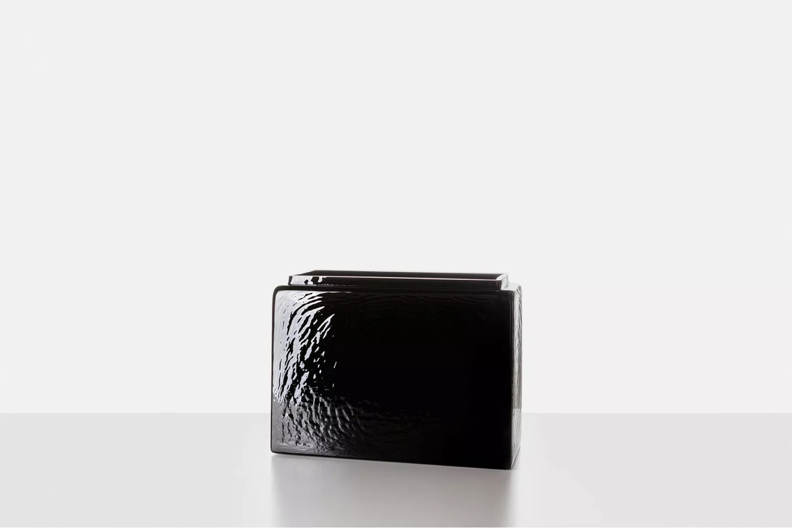 Black textured wallet on white background.