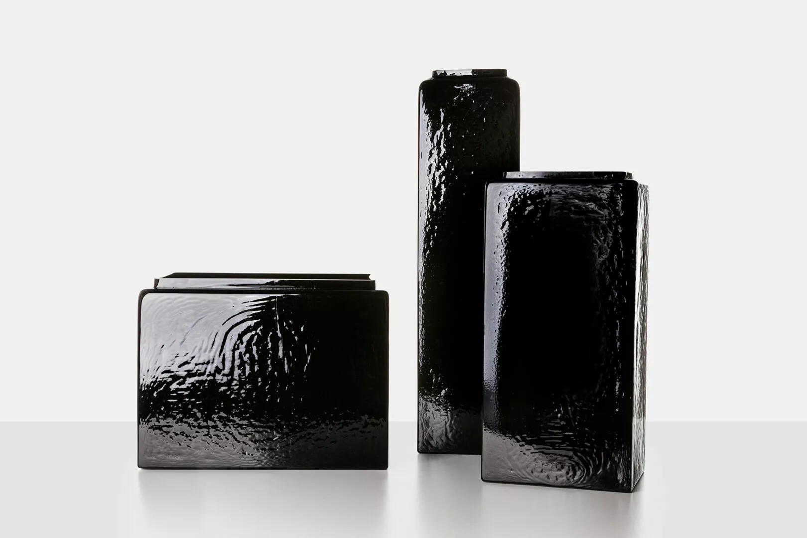 Black textured ceramic vases on white background.