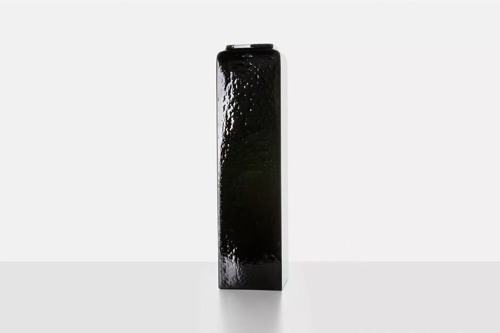 Black, wet, upright beverage can on white background.