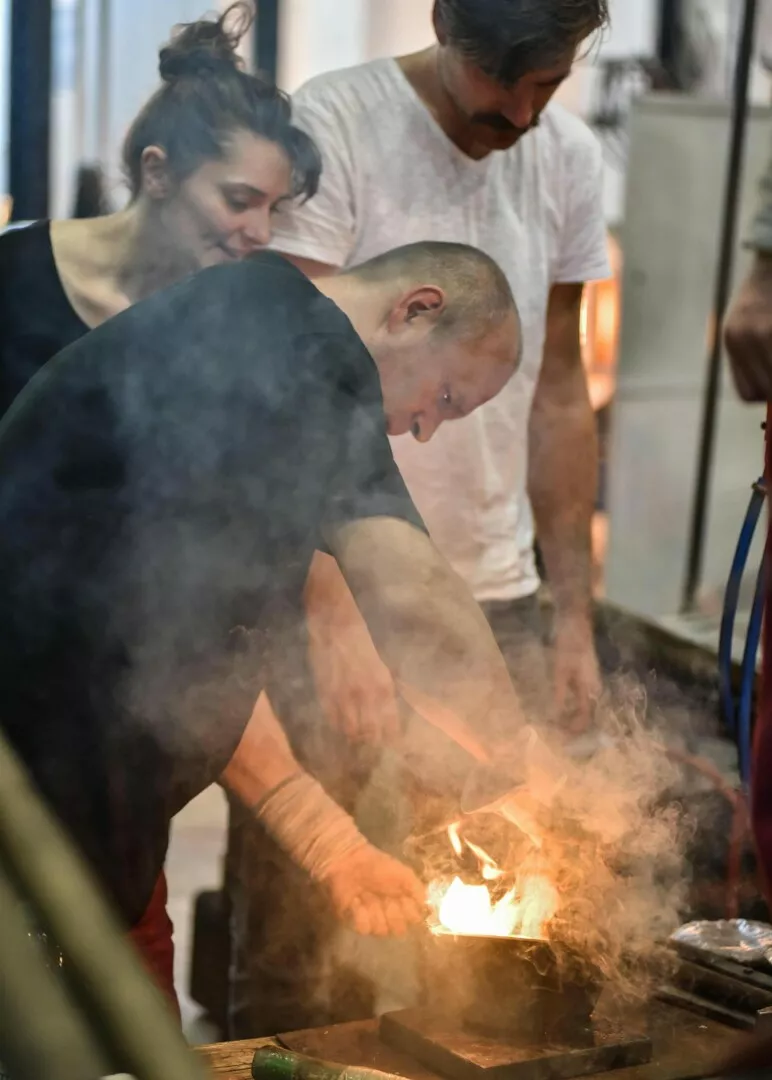 Blacksmiths forging metal with fire in workshop.