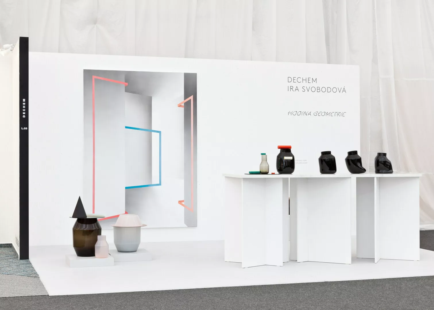 Minimalistic design exhibit with geometric vases and decor.