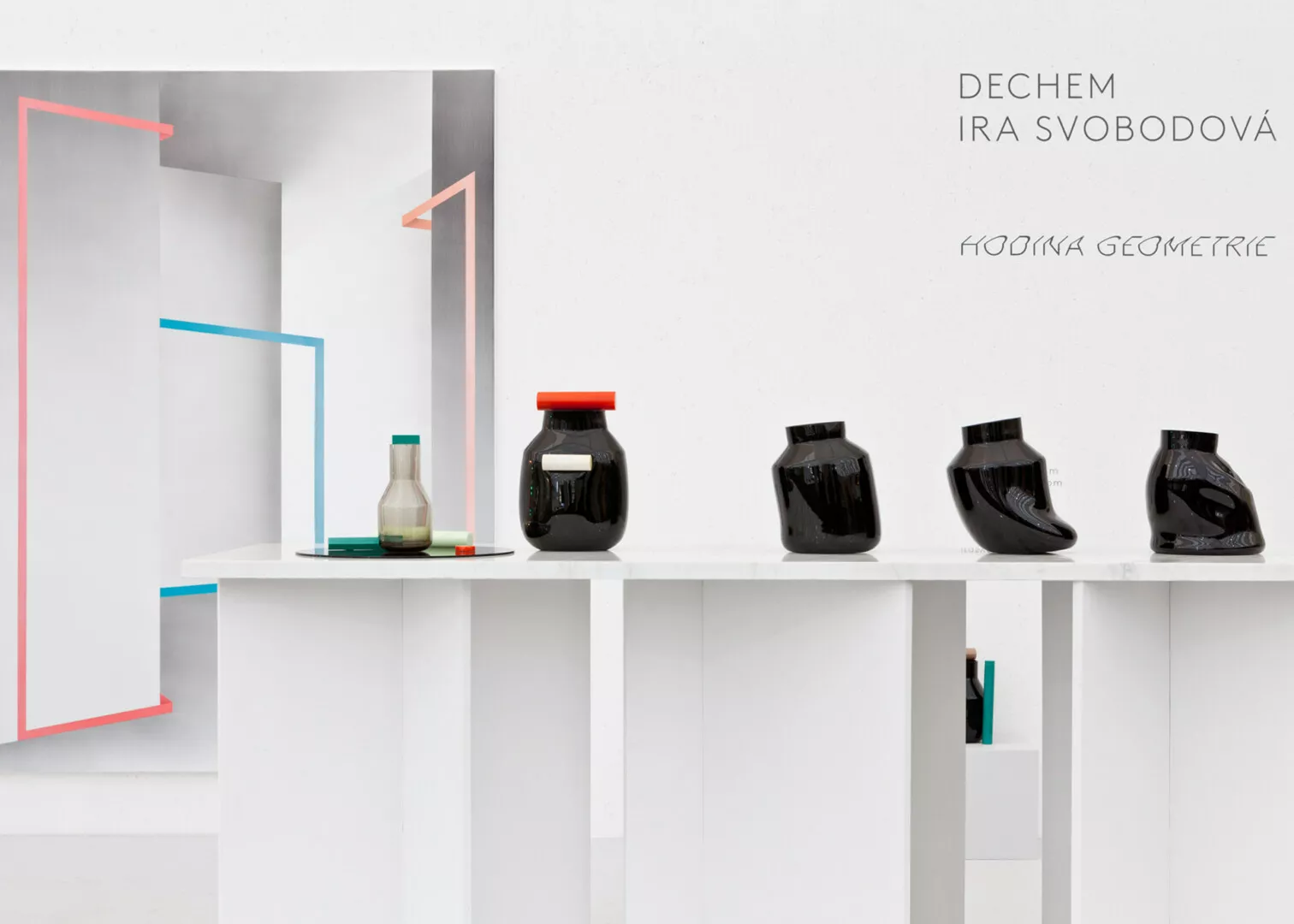 Modern art display with geometric shapes and black jars.