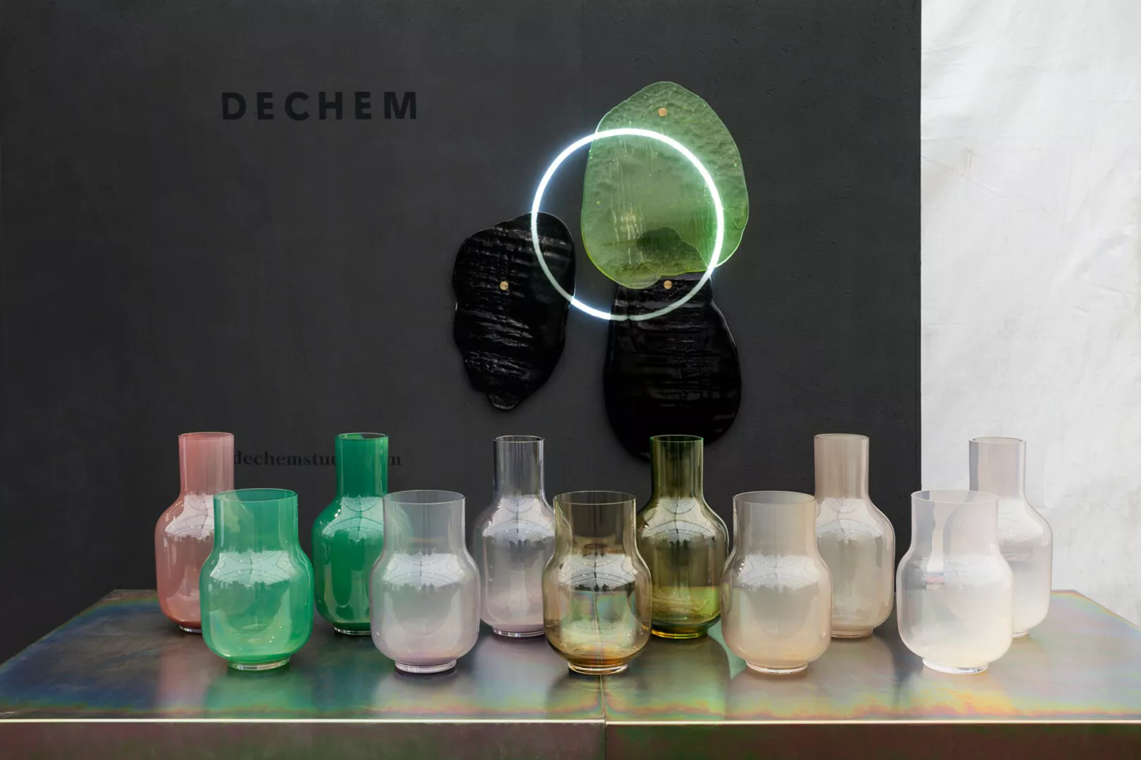 Colorful glass vases displayed under modern lighting.