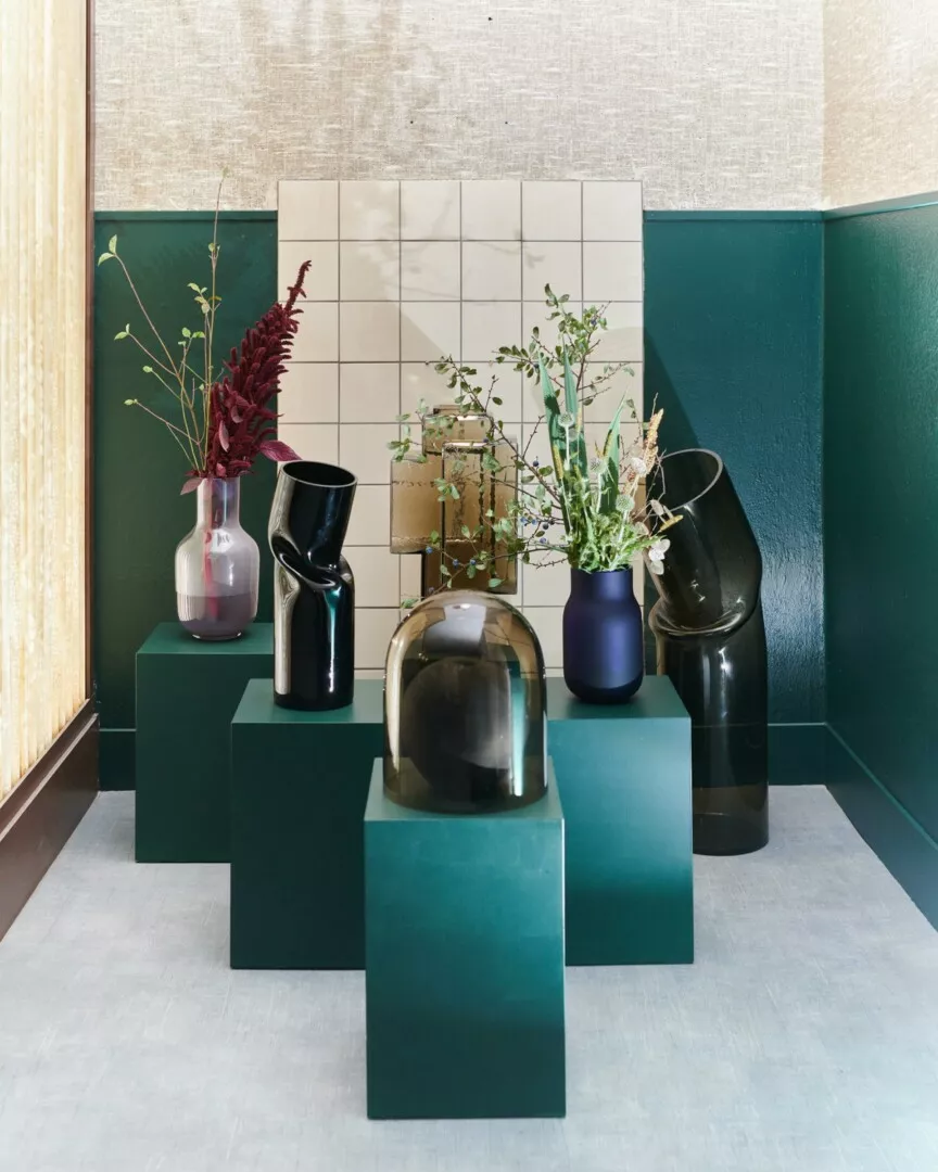 Modern vases on pedestals in stylish interior.
