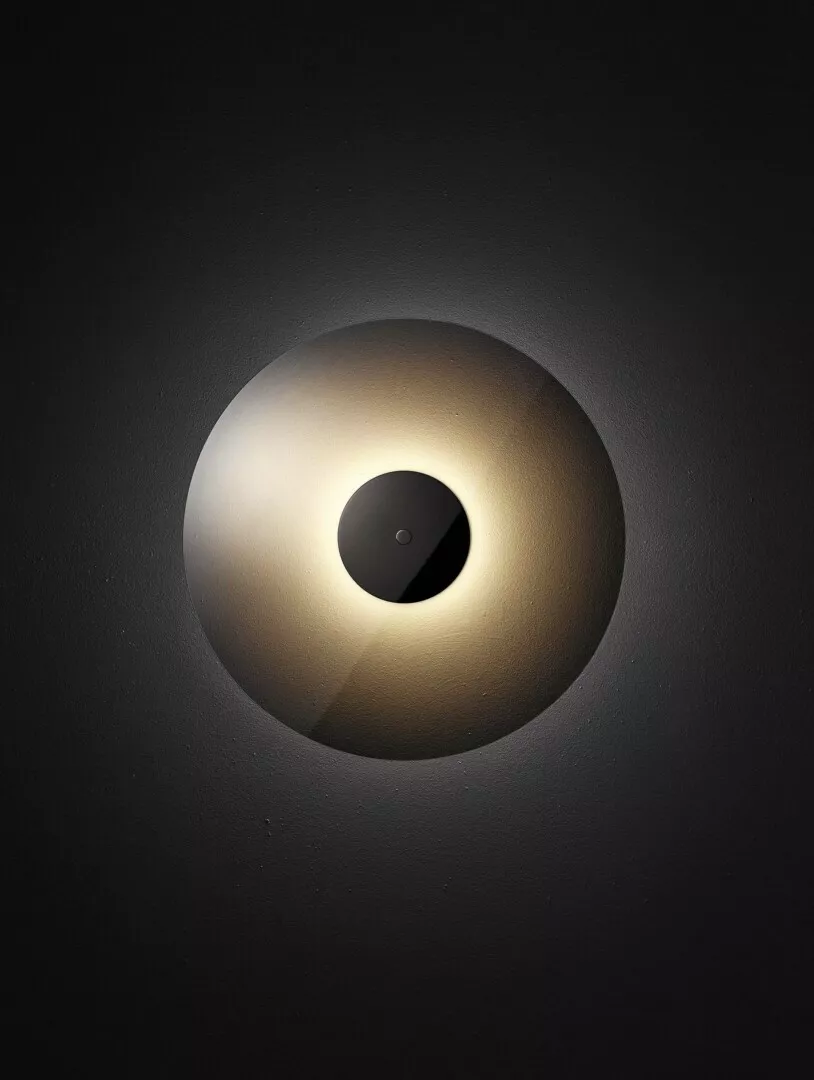 Minimalist spotlight on black background with glowing center.