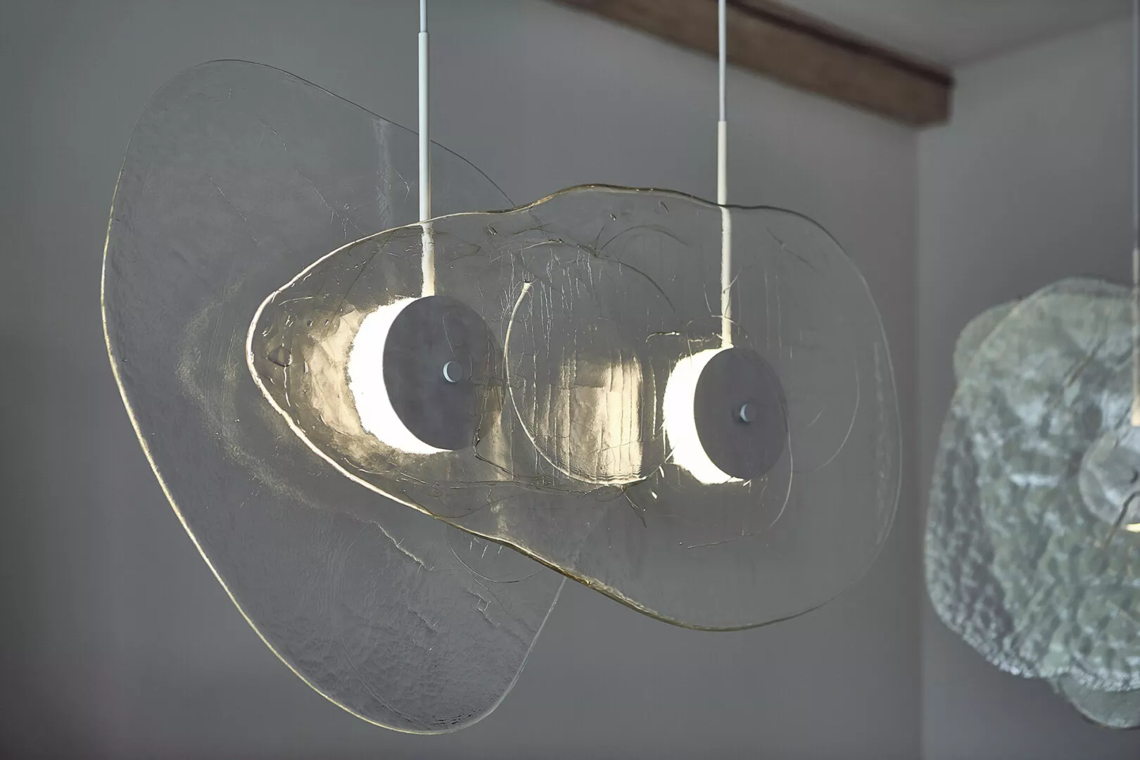 Modern layered glass pendant lights hanging indoors.