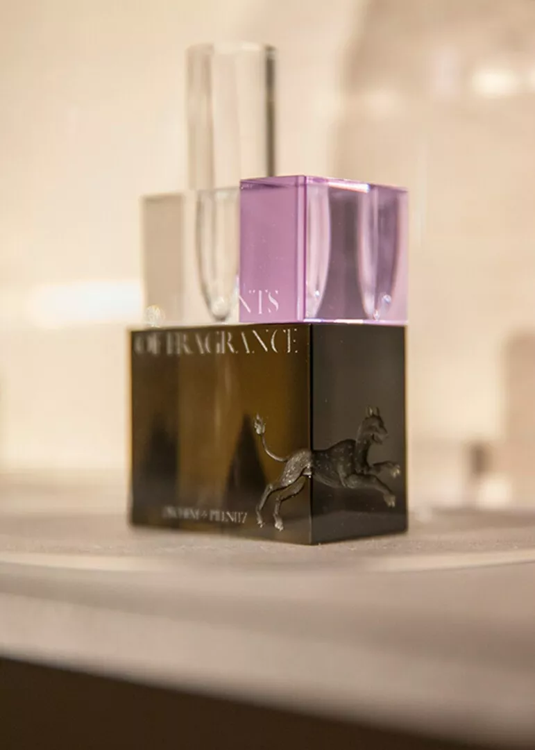 Elegant perfume bottles on display with horse emblem.
