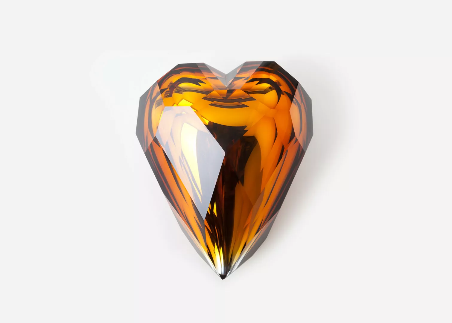 Orange reflective heart-shaped glass sculpture on white background