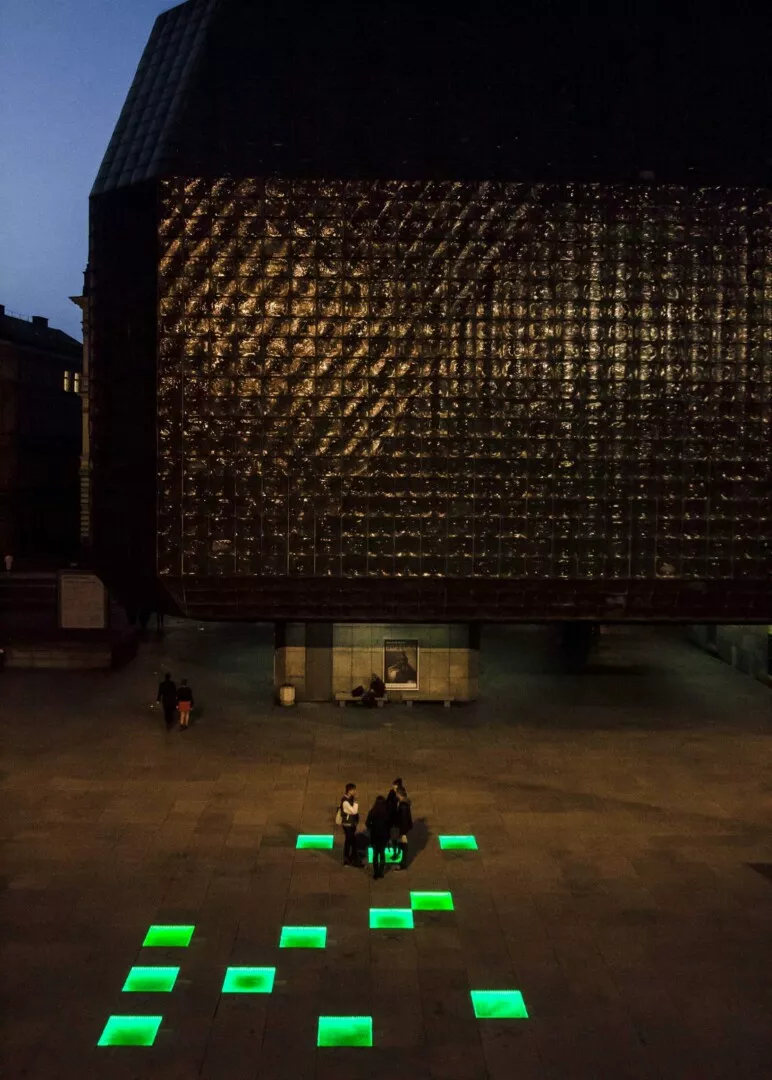 Illuminated building facade at night with green lights.