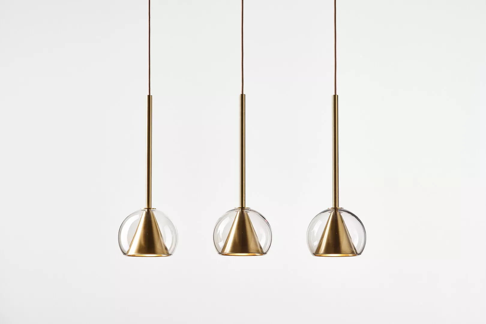 Three hanging glass and gold pendant lights.