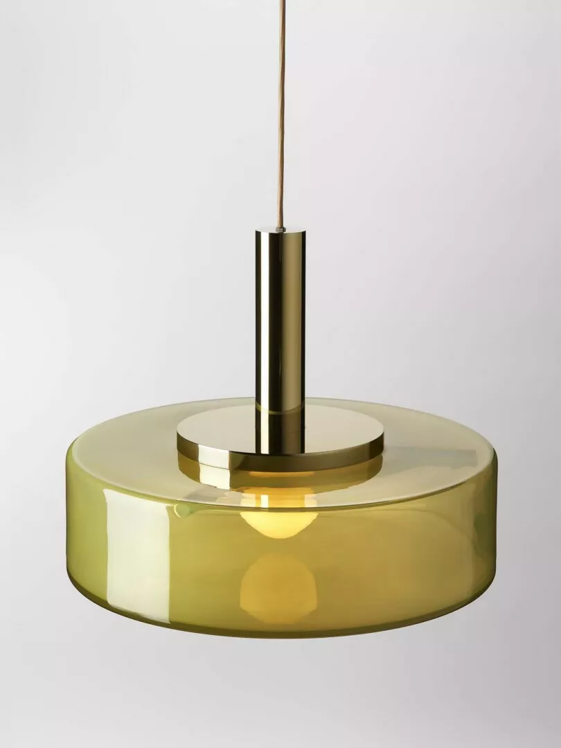 Modern amber glass pendant light with brass fixtures.