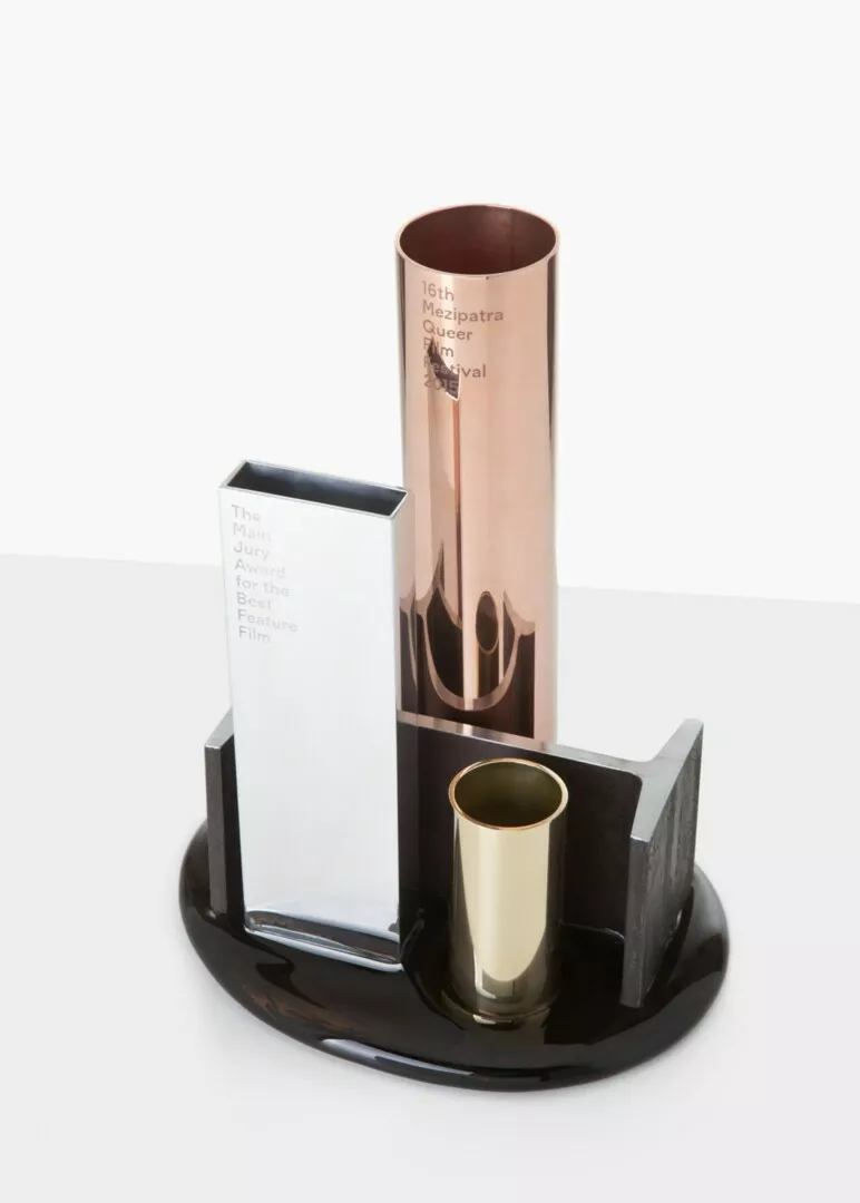 Copper award trophy for film festival on black stand.