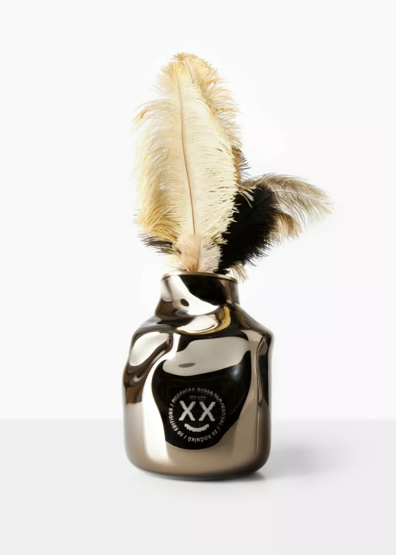Shiny ink bottle with feather quill, isolated on white.