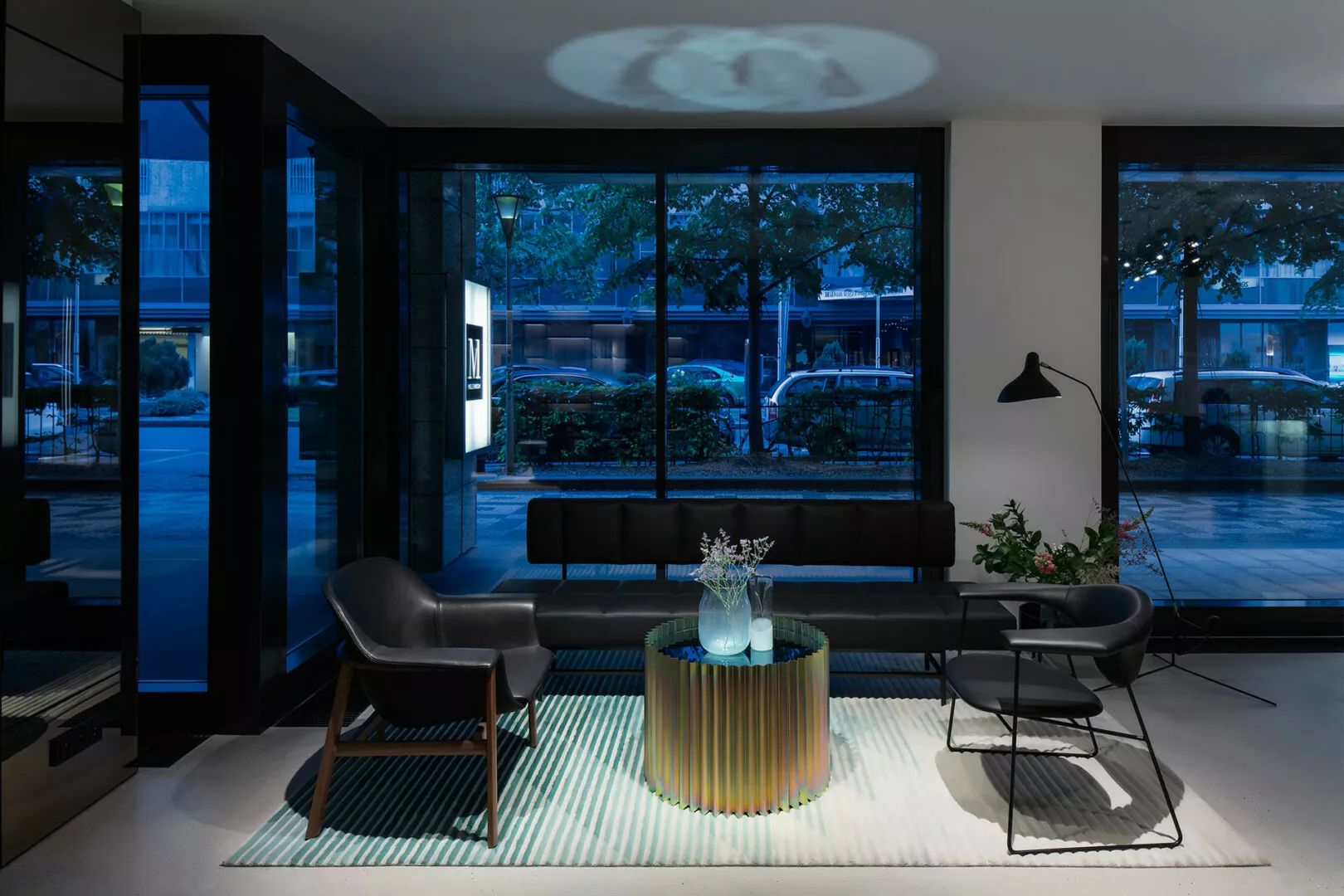 Modern lobby with stylish furniture and large windows.
