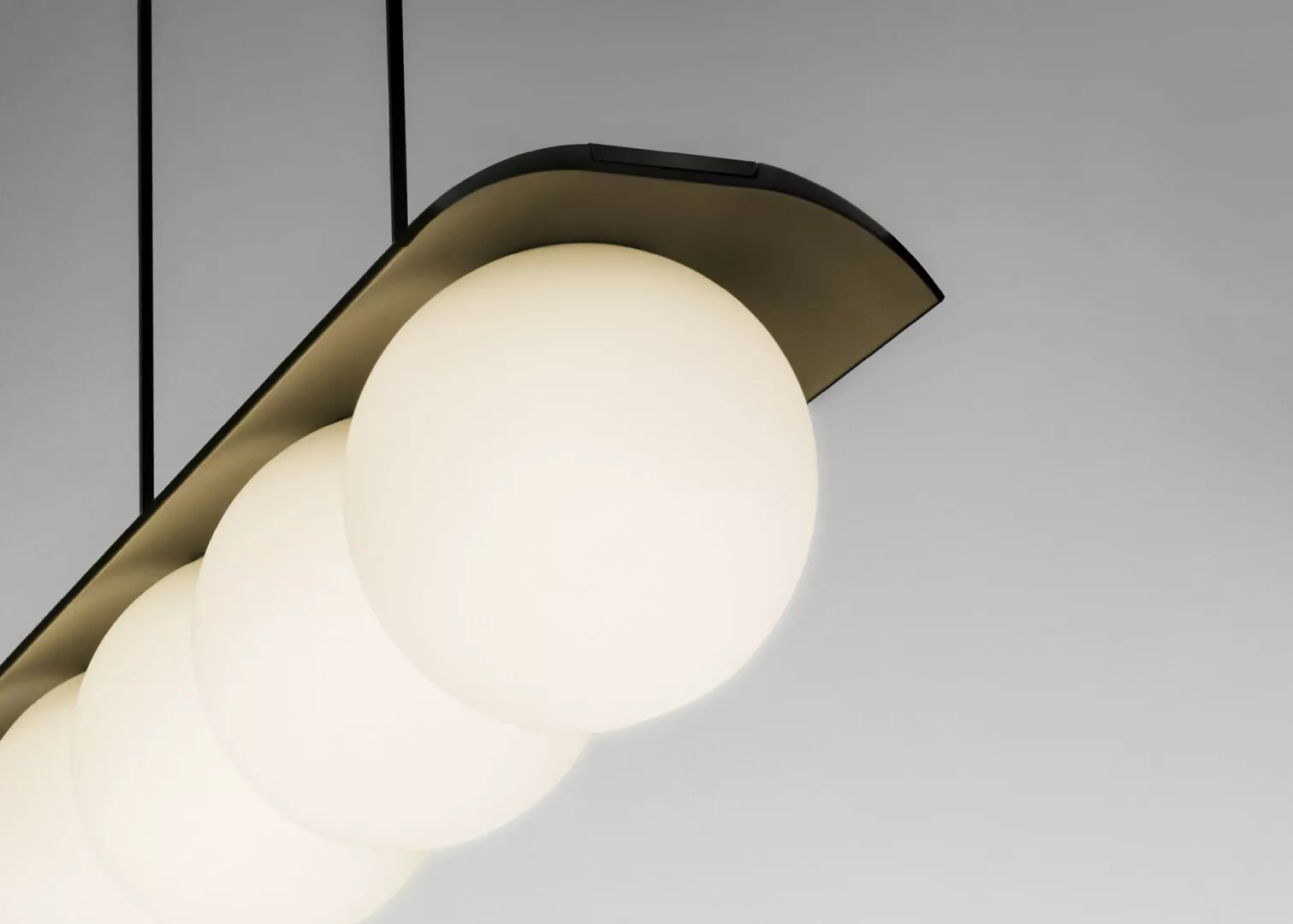 Modern pendant light with glowing spherical bulbs.