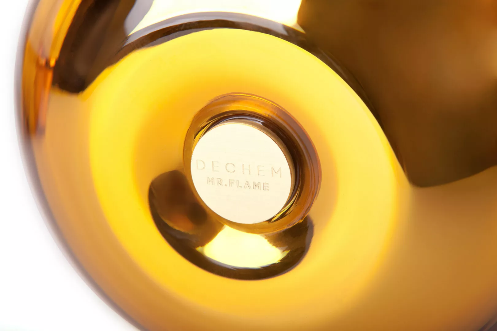 Close-up of golden candle holder labeled "DECHEM MR.FLAME