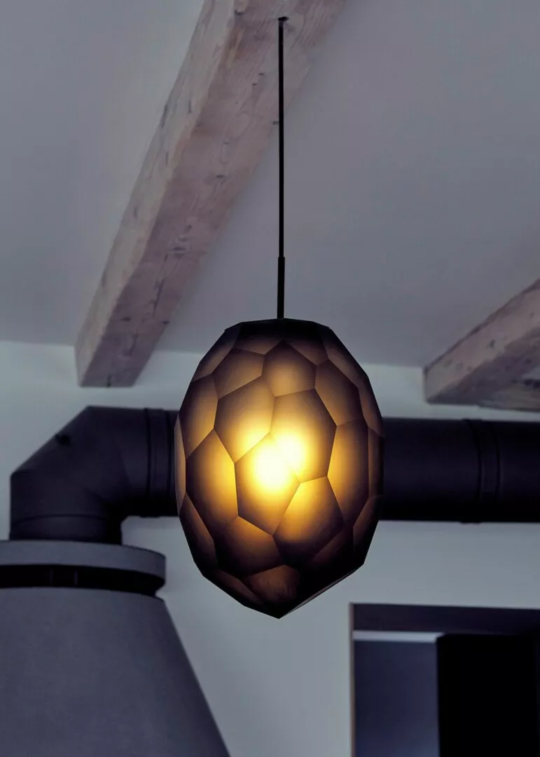 Geometric pendant light illuminating modern room.