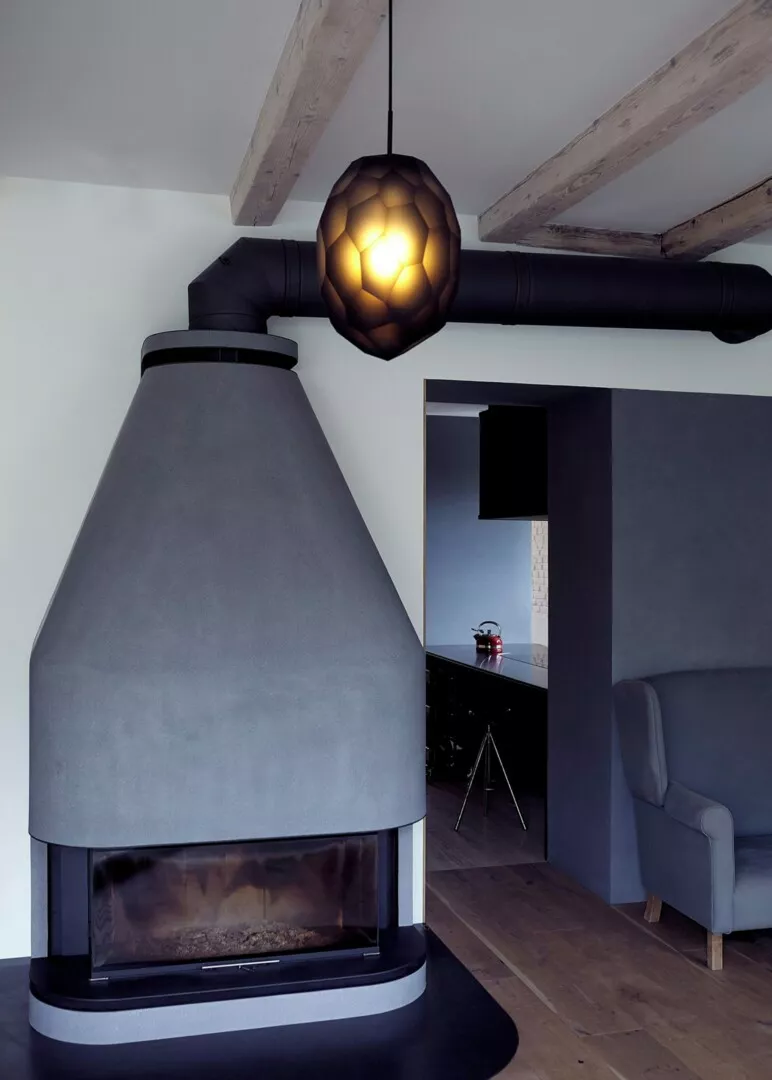 Modern fireplace and geometric pendant light in stylish room.