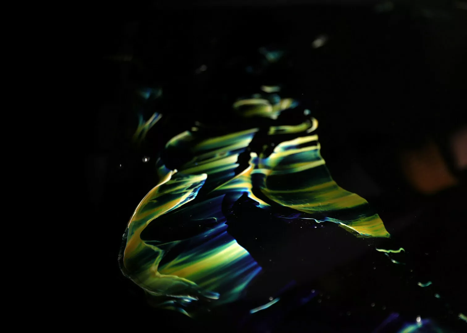 Vibrant abstract neon paint swirls on dark background.