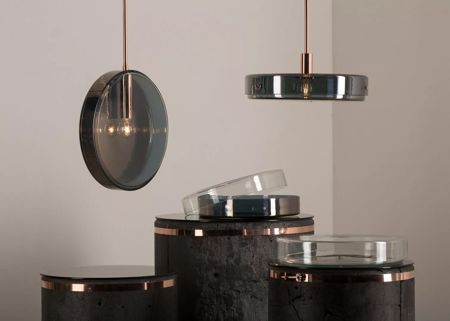Modern copper pendant lights over black marble tables.