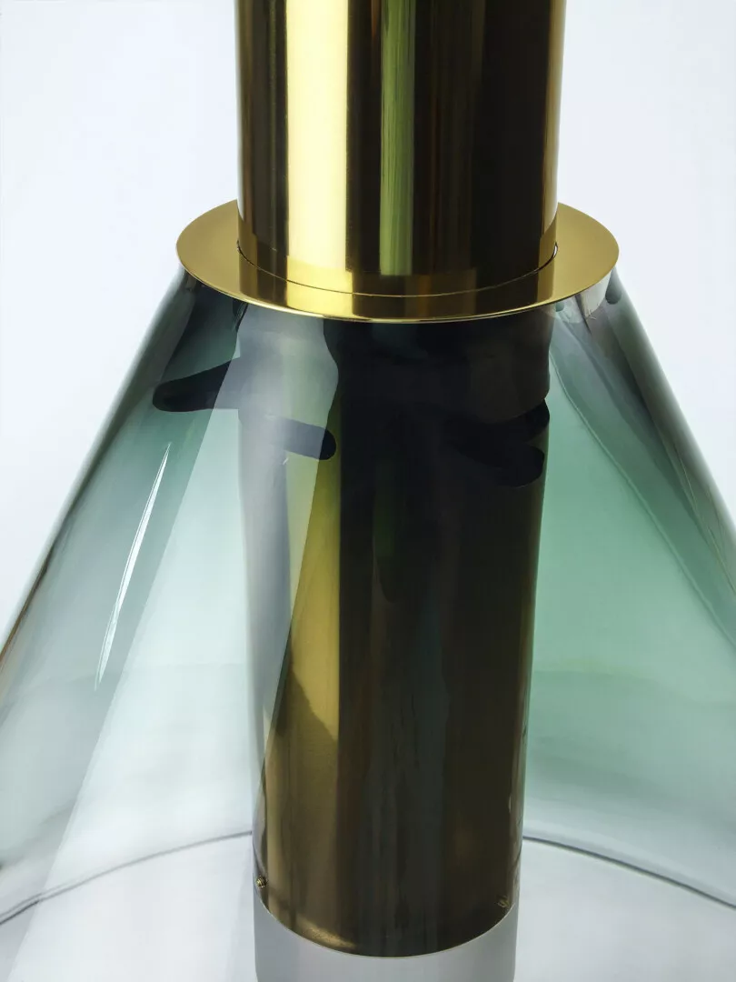 Close-up of modern glass vase with gold accents.