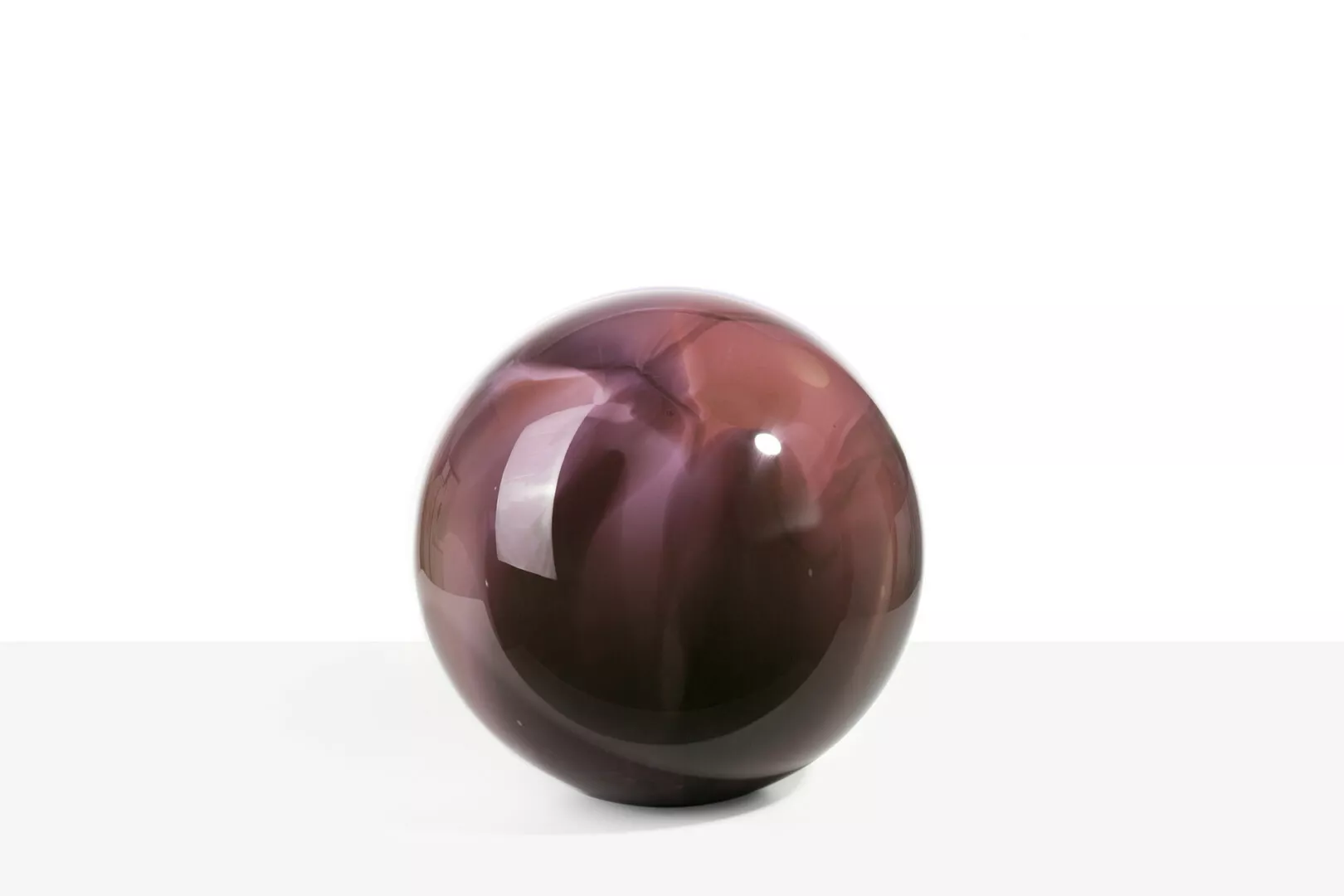 Glossy purple sphere on plain white background.