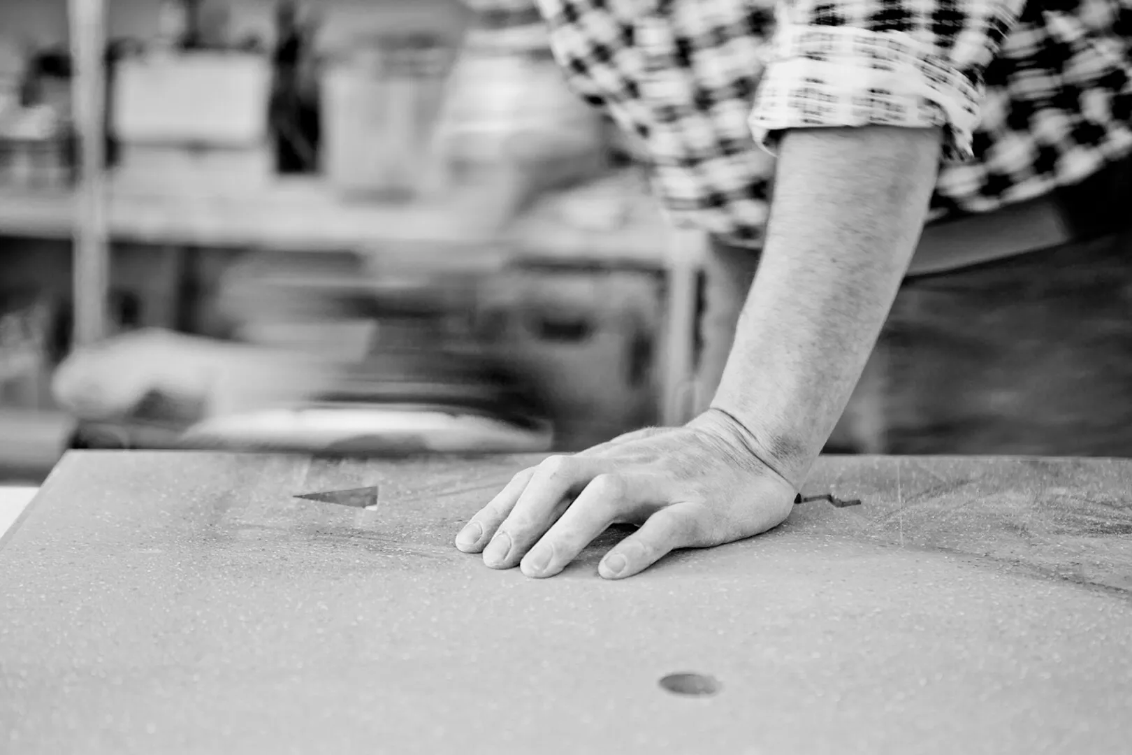 Person measuring on large paper, black and white photo.