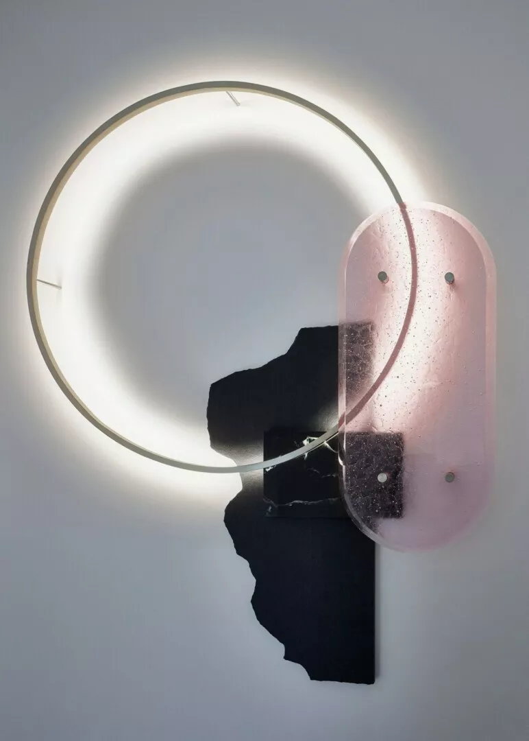 Modern wall-mounted circular light with pink glass.