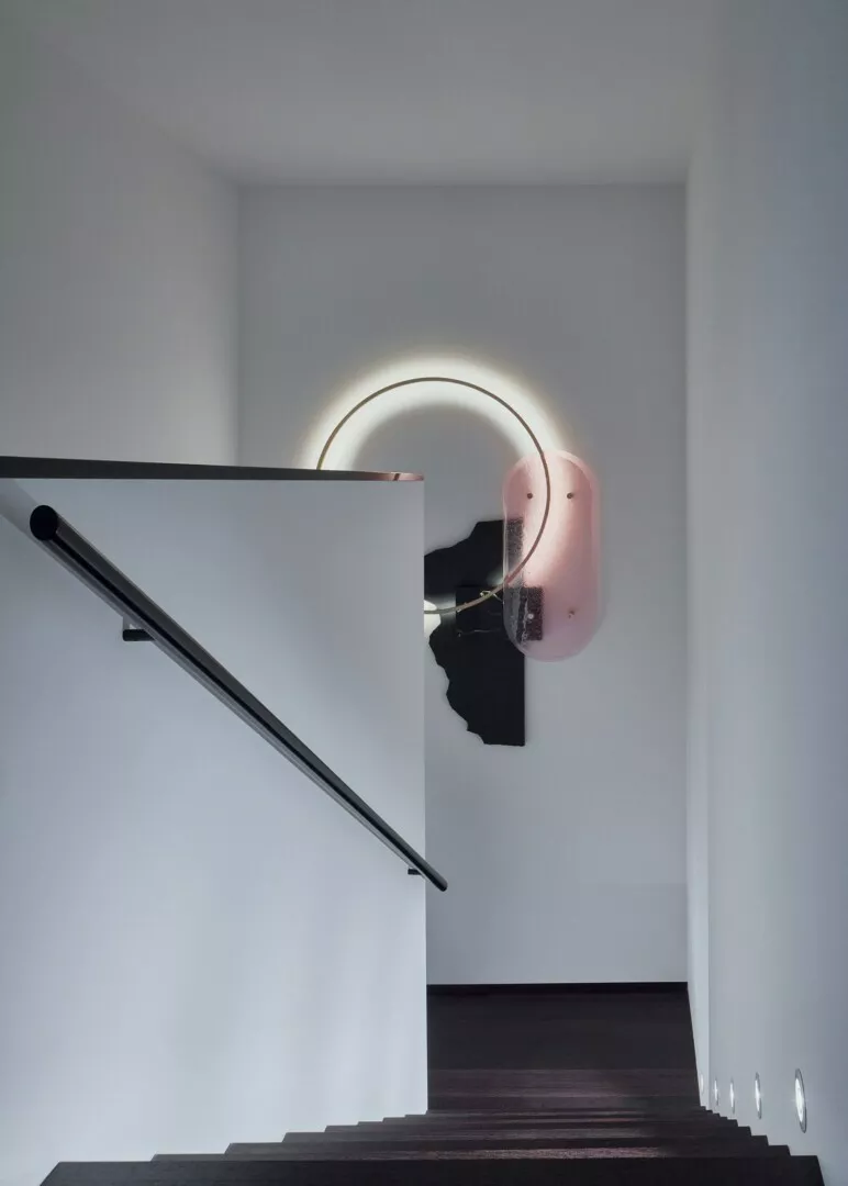 Minimalistic staircase with circular wall light.
