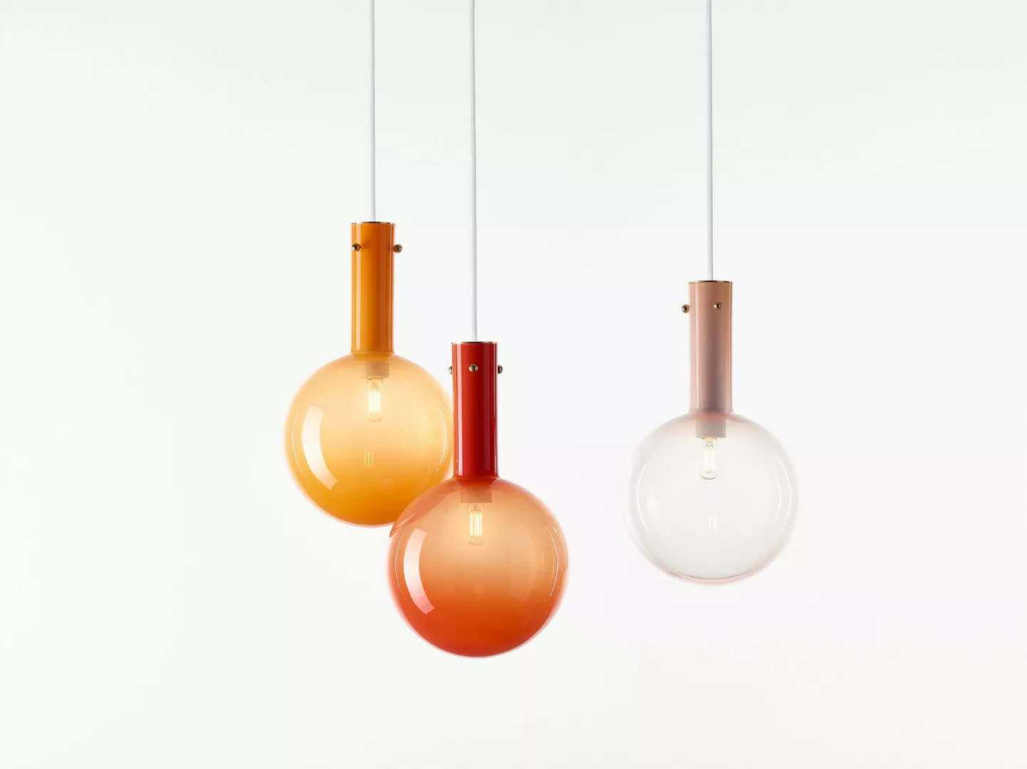 Three hanging pendant lights in orange gradients.