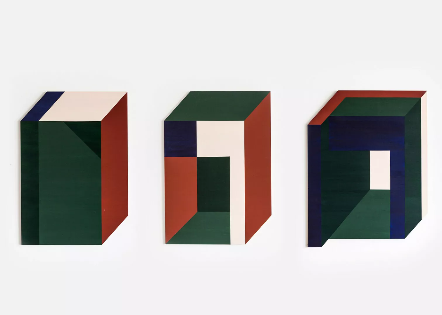 Three geometric abstract sculptures, red, green, blue hues.