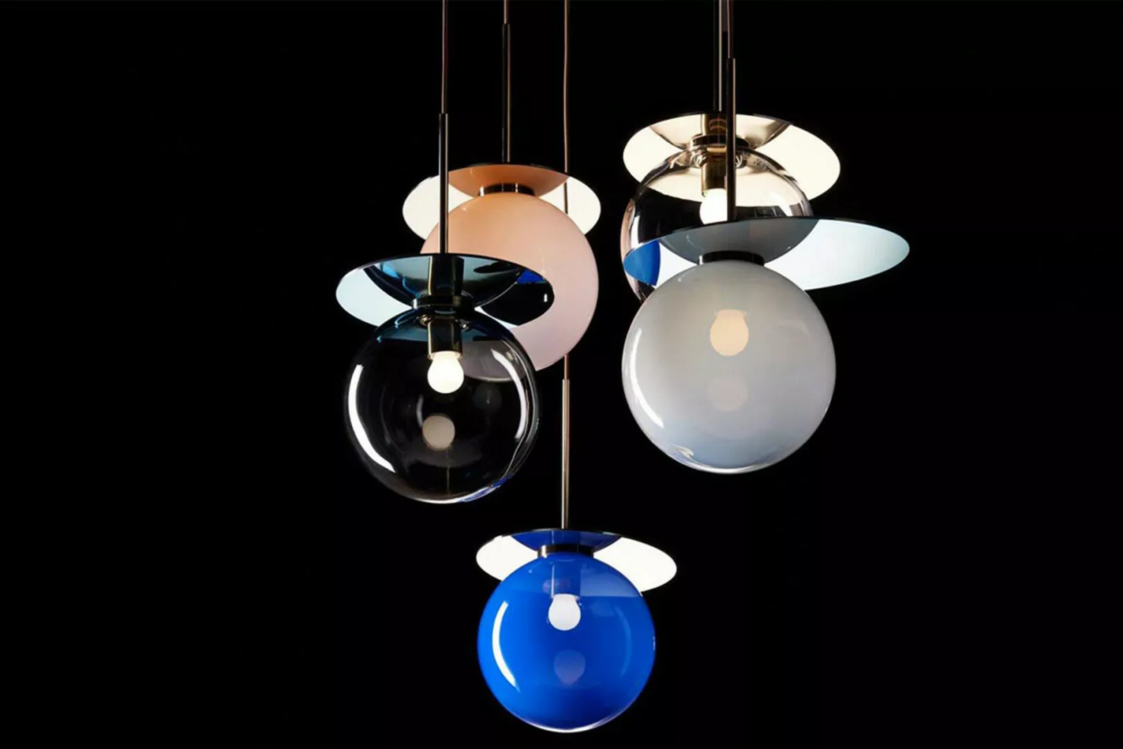 Colorful modern pendant lights against a black background.