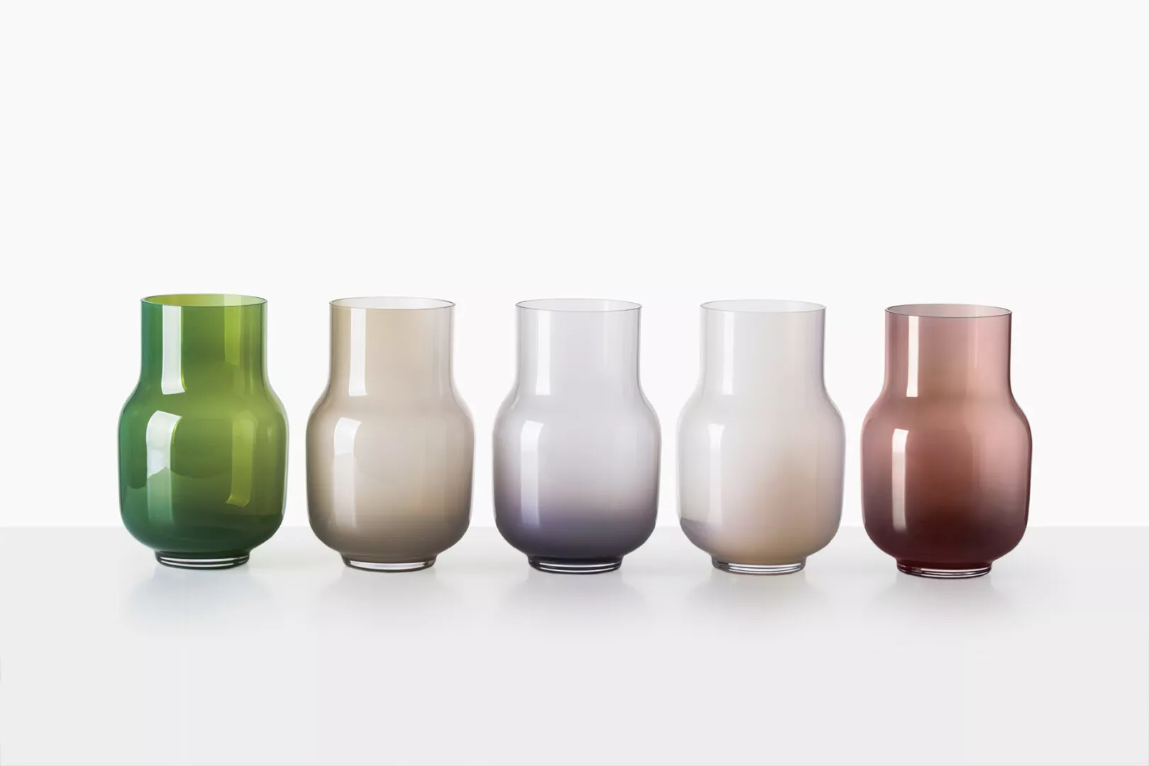 Colorful glass vases in a row on white background.