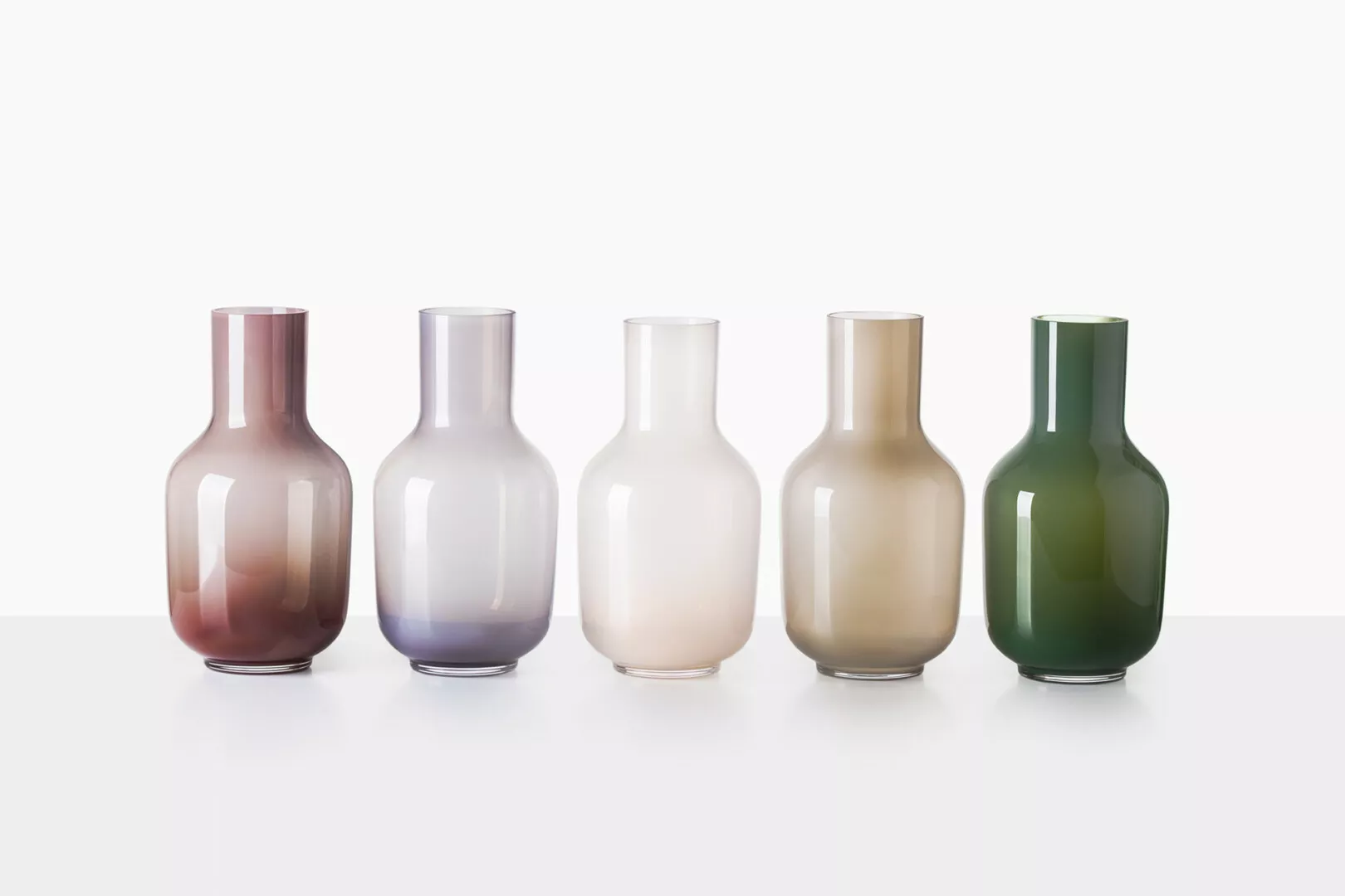 Five gradient colored glass vases on white background.
