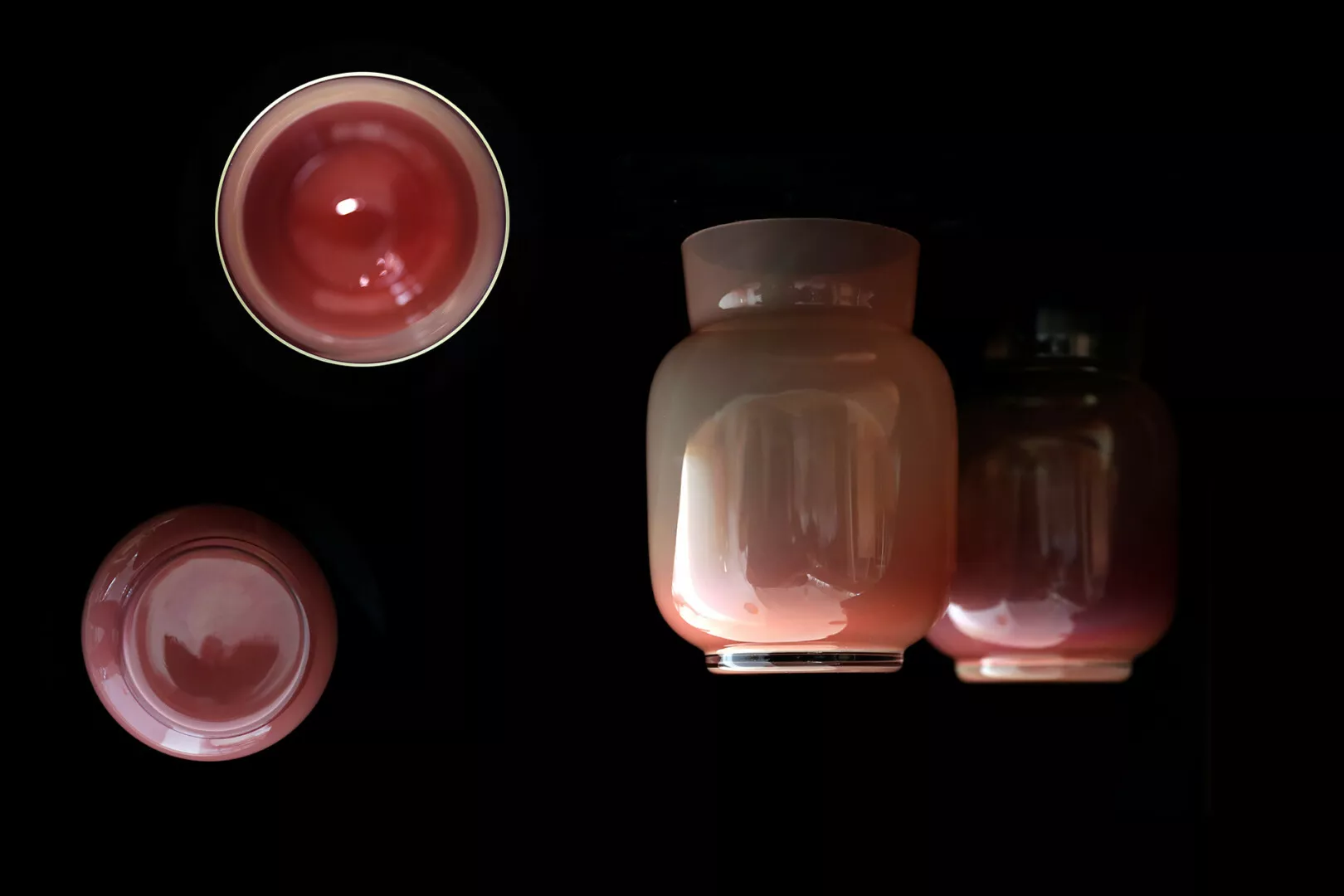 Three glass jars with red contents on black background.