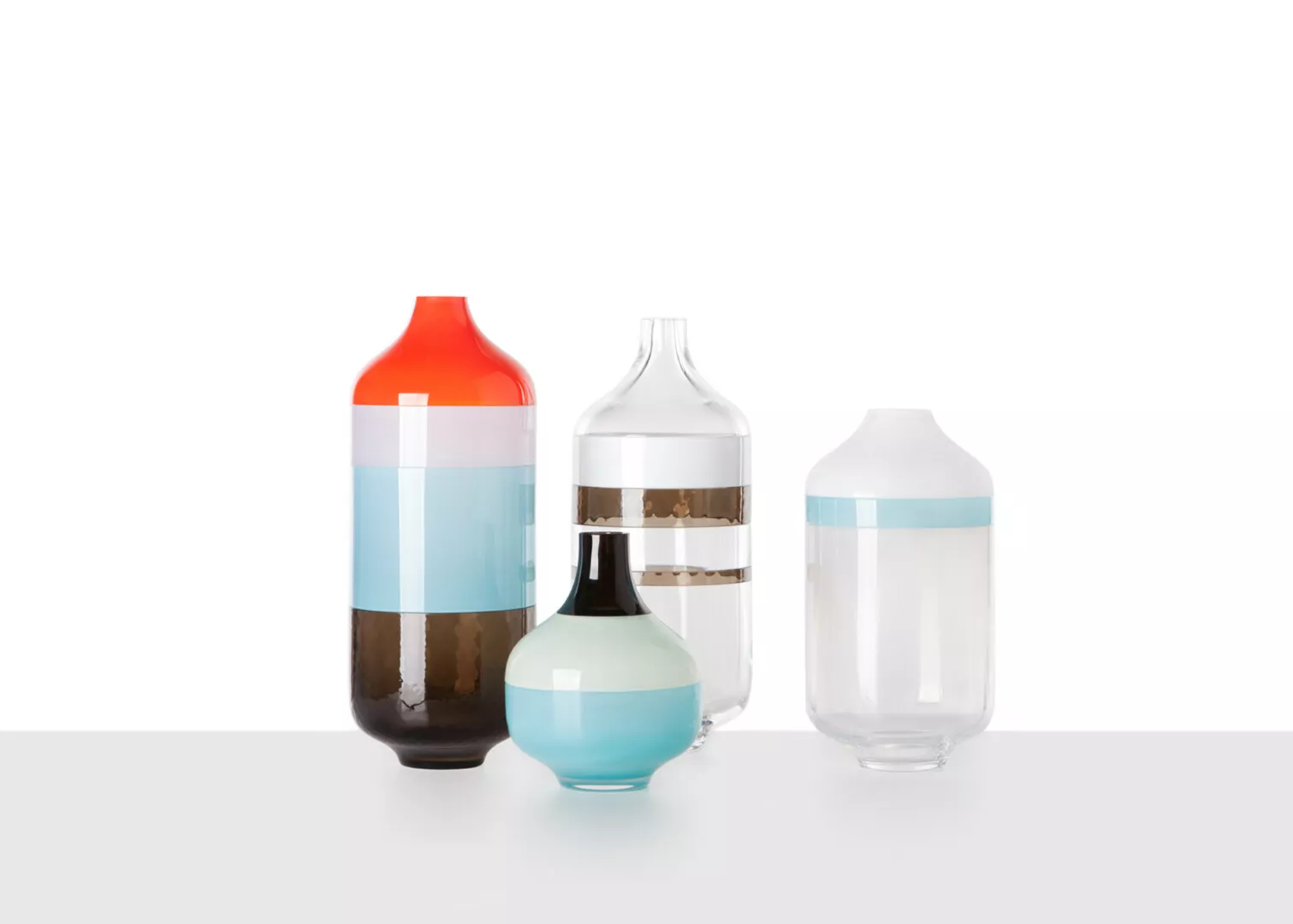 Colorful glass bottles with liquid on white background.