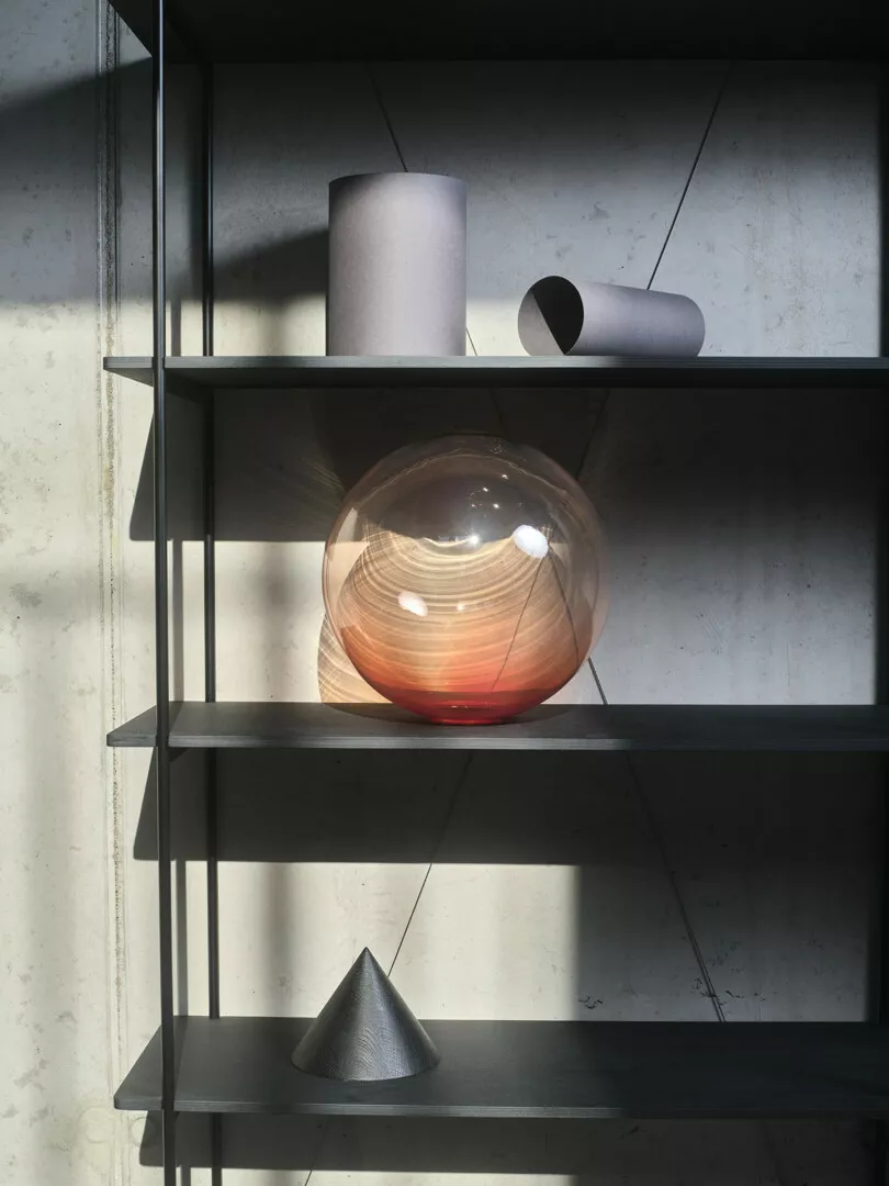 Modern shelf displaying geometric shapes and textured vase.