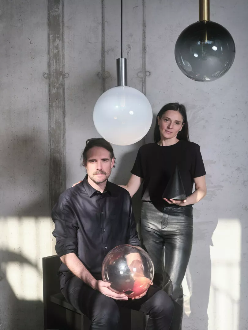 Man and woman with designer lamps in modern interior.