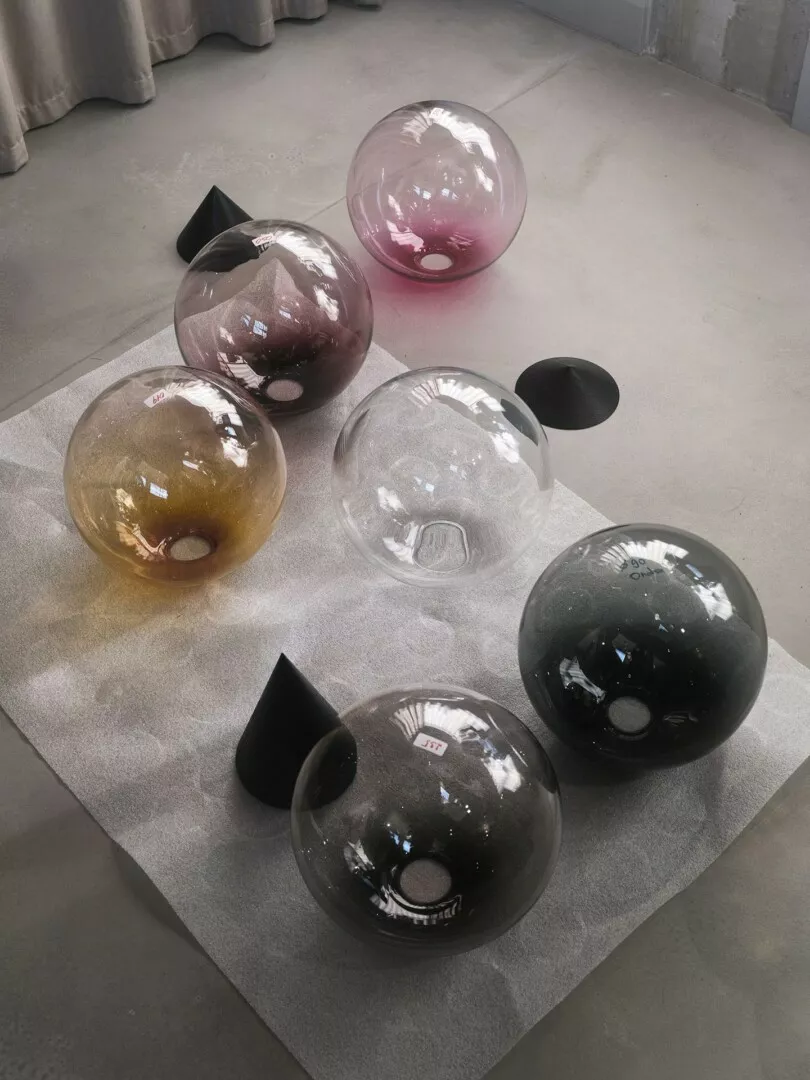 Colorful glass orbs on gray floor, artistic display.